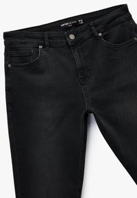 Czarne dżinsy slim fit wykonane z mieszanki bawełny, z zapięciem na guzik, pięcioma kieszeniami i subtelnymi detalami przeszycia. Rozmiar W32 L32.