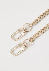 Gold metal chain strap featuring interlocking links and two snap hook clasps for attachment. Smooth texture with a shiny finish.