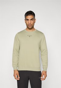 Lys grøn sweatshirt med langeærmer, rund halsudskæring og ribbede manchetter. Har "HYROX" logo i sort på brystet. Glat tekstur.