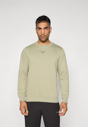 Light green sweatshirt with long sleeves, round neckline, and ribbed cuffs. Features "HYROX" logo in black on the chest. Smooth texture.