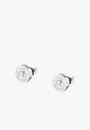 Boucles d'oreilles clous rondes en argent avec des cristaux centraux clairs gravés de "KARL LAGERFELD" autour du bord, présentées sur fond blanc.