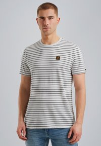 T-shirt gris à manches courtes avec des rayures horizontales noires, col rond et un petit patch logo carré sur la poitrine.