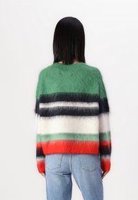 Knitted sweater with green, red, navy, white, and grey stripes. Made of fuzzy material, featuring a round neckline and relaxed fit.