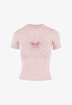 Pink short-sleeve shirt with a fitted design. Features a butterfly motif in red rhinestones, surrounded by smaller red stones in a radiant pattern.