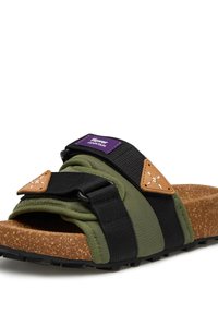 Landscape-style sandals feature green fabric straps, black nylon, brown cork footbed, and an adjustable buckle. Branding label in purple.