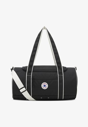 Čierna cestovná taška s bielymi akcentmi a popruhmi, zobrazujúca okrúhle logo Converse All Star, horný zips a ďalší predný vrecko.