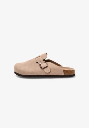 Zueco beige de ante tipo slip-on con correa ajustable con hebilla, plantilla de corcho y suela de goma negra, mostrado de perfil sobre fondo blanco.