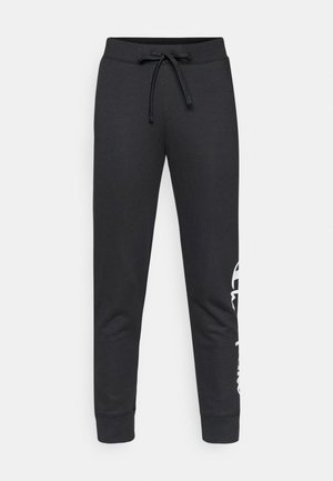 Μαύρο βαμβακερό παντελόνι φόρμας με κορδόνι στη μέση, στενό σε όλο το μήκος, με λευκό λογότυπο τυπωμένο στη μία πλευρά. Λείο ύφασμα.