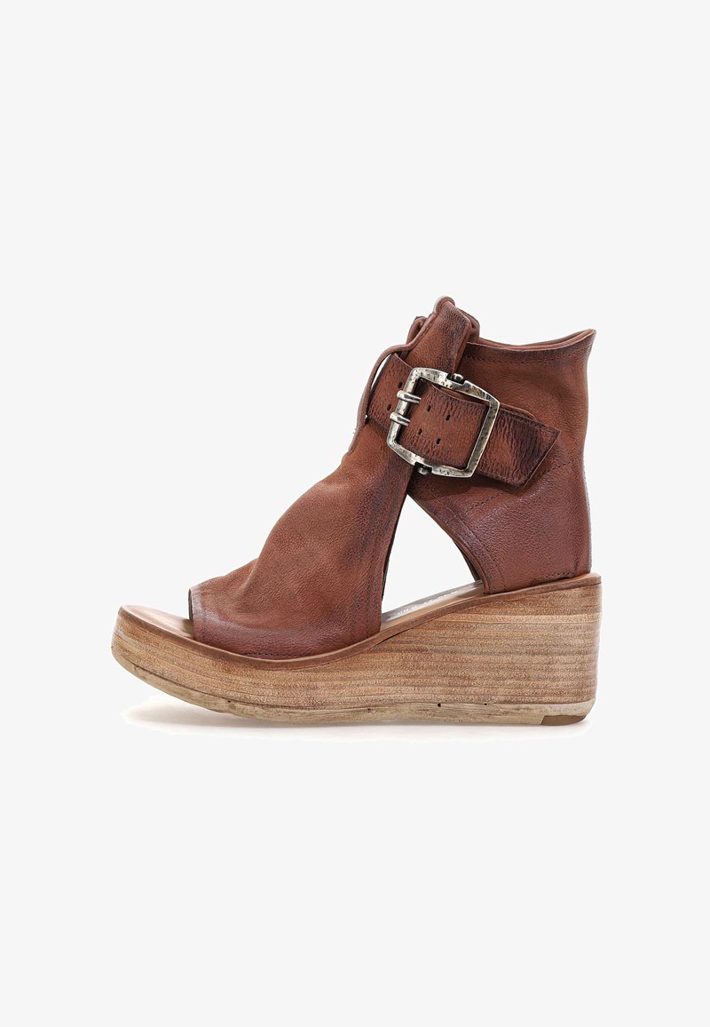 Brune læder wedge sandal med åben tå, ankeludskæringer og en stor sølvspænde detalje. Tekstureret træplatformsål.