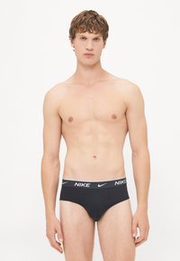 Schwarze Baumwollslips mit einem weichen Bund, der das Nike-Logo in Weiß trägt. Entwickelt mit einer engen Passform und minimalen Nähten.