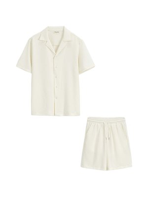 Chemise crème à manches courtes boutonnée et shorts assortis à taille élastique avec un motif texturé subtil sur fond blanc.