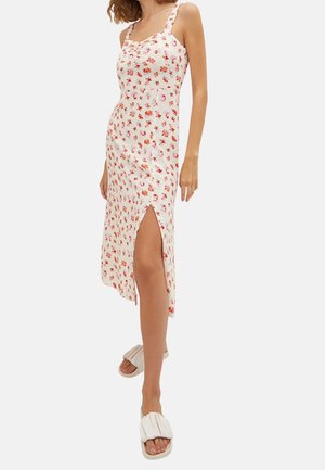 Robe midi florale en crème clair avec des motifs orange et rose, bretelles fines, décolleté arrondi et fente haute à gauche.