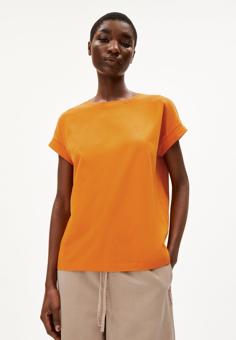T-shirt en coton orange avec des manches retroussées et un logo brodé sur la poitrine. Il présente une coupe décontractée et une texture lisse.
