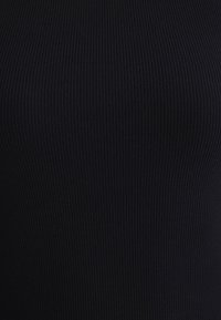 Black ribbed fabric with a textured surface, featuring vertical stripes that create a fitted and streamlined appearance.