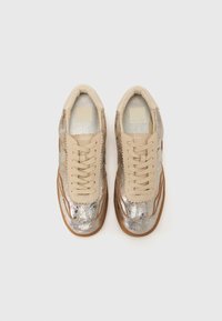 Sneakers featuring a metallic silver upper with beige leather accents, round toe, flat laces, and a rubber sole with a textured design.