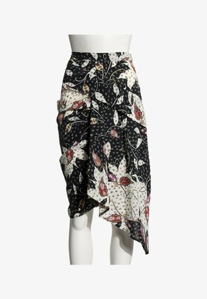 Jupe asymétrique noire et blanche avec imprimé floral abstrait et cachemire, portée sur un mannequin blanc.