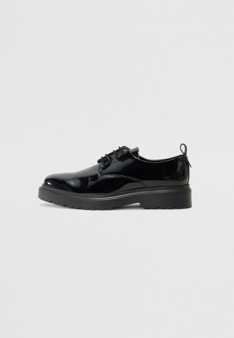 Chaussures en cuir verni noir avec un bout arrondi, un design à lacets et une semelle en caoutchouc épaisse. Elles sont dotées d'une languette à l'arrière pour faciliter l'enfilage.