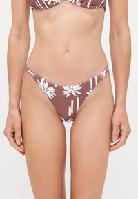 Rjavi bikini spodnji del z belimi cvetnimi vzorci in vertikalnimi črtami. Ima nizko rez, elastične naramnice za prilegajoč dizajn.