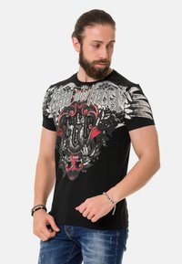 Schwarzes T-Shirt mit einem komplizierten grafischen Design in Grau, Rot und Weiß, mit einer strukturierten Oberfläche auf der Brust und kurzen Ärmeln.
