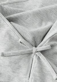 Gray fabric with a soft texture, featuring a tied accent at the back and visible stitching details, creating a relaxed design.