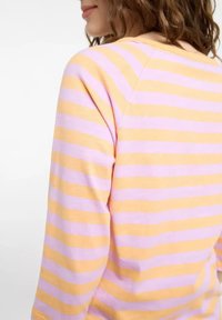 Gestreiftes langärmliges Oberteil in abwechselnden Pastellfarben Pink und Gelb. Weicher Stoff mit weitem Halsausschnitt und Raglanärmeln.