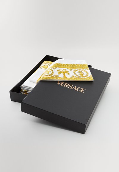 Versace siidist taskurätikud mustas karbis. Valge kangas kuldsete barokkmustritega, millel on keerukad disainid ja tekstuurid.