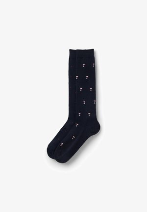 Marineblaue Socken aus weichem Material, mit einem wiederholten Muster aus kleinen Weingläsern und roten Punkten. Standarddesign in Knöchellänge.
