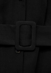 Black fabric belt with a rectangular buckle, smooth texture, and sturdy stitching. Features a button below the belt for closure.
