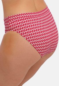 Bikini kalhotky s červeným a bílým vzorem mají vysoký pas a geometrický potisk, jsou vyrobeny z elastického materiálu pro maximální pohodlí.