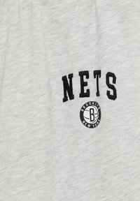 Grauer Stoff mit dem Wort "NETS" in fetter, schwarzer Schrift über einem runden Logo, das "BROOKLYN" und "NEW YORK" in einem kreisförmigen Design zeigt.