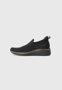 Sorte slip-on sko med en teksturert strikket overdel, en avrundet tå og en polstret såle. Har en subtil kontrasterende gullkant langs bunnen.