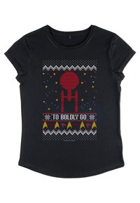 Camiseta negra con un gráfico de una nave estelar roja, acentos de patrón tejido y el texto "PARA AVENTURARSE", con detalles coloridos similares a estrellas en la parte superior.