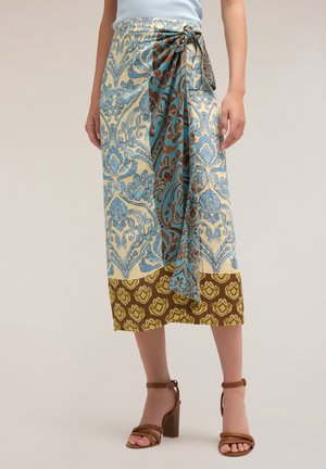 Wikkelrok met een blauw, beige en bruin bloemmotief, geknoopt in de taille. Gemaakt van zachte stof, valt deze tot halverwege de kuit met een contrasterende zoom.