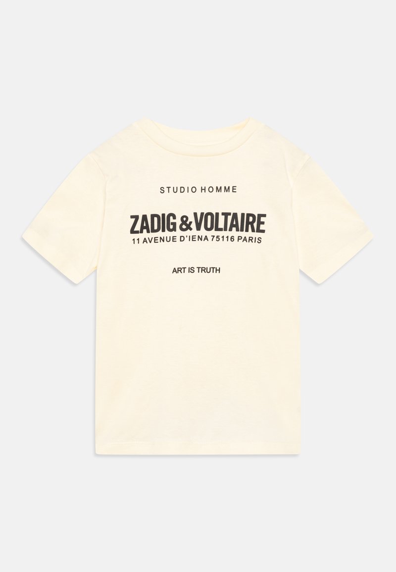 Krēms krāsas kokvilnas T-krekls ar īsām piedurknēm, apaļu kakla izgriezumu, melniem drukātiem uzrakstiem un logotipa detaļām priekšpusē.