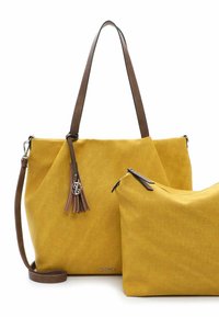 Gele tote bag met bruin leren handvatten, voorzien van een kwastaccent en een kleinere bijpassende pouch. Glad van textuur, hoekig ontwerp.