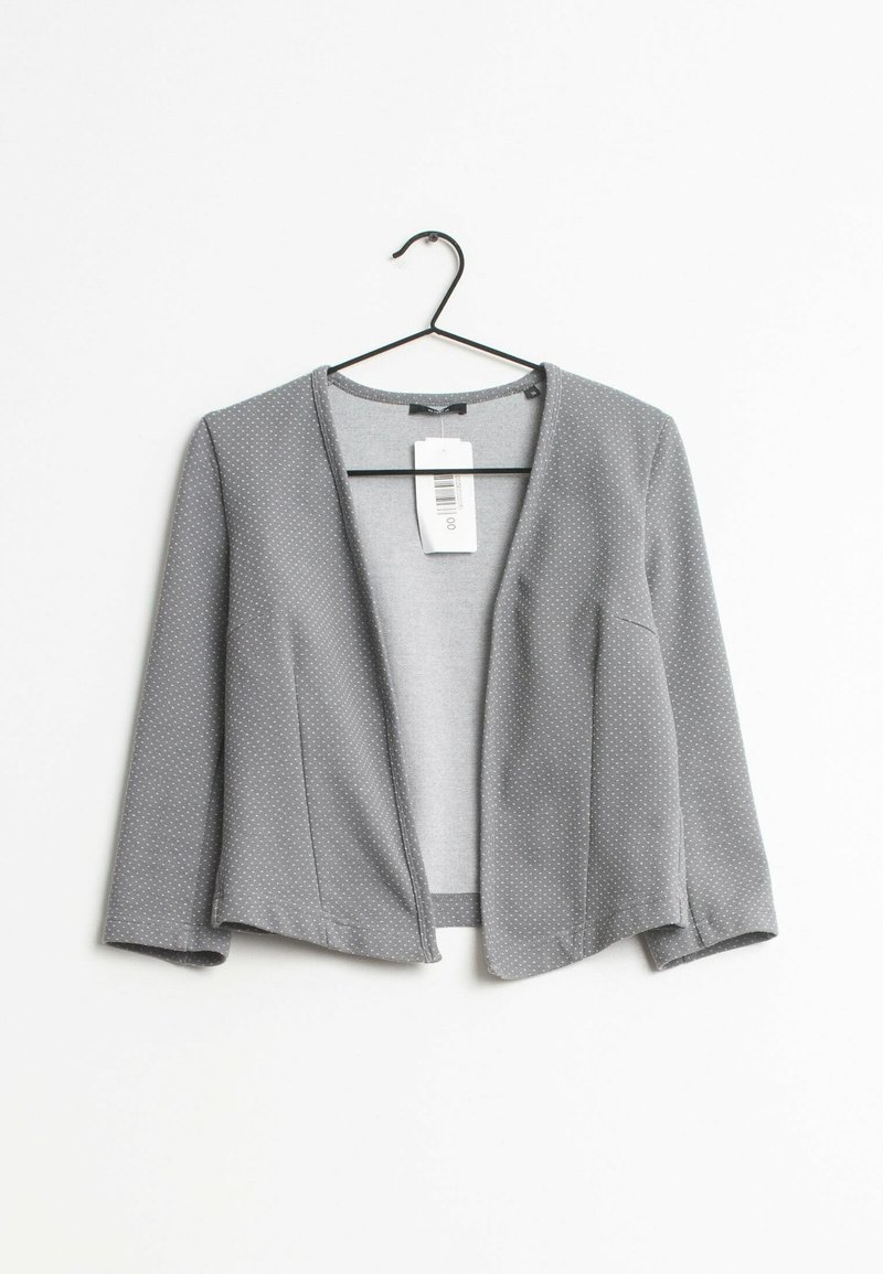 Gray, polka-dotted cropped jacket with a loose fit, open front, and three-quarter sleeves, hanging on a black hook against a white background.