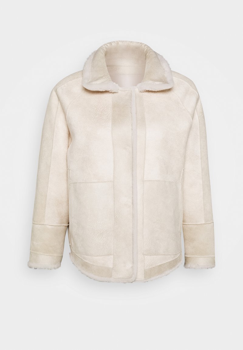 Veste en fausse fourrure couleur crème avec une texture douce, un large col et des poches avant. Présente une coupe droite et des détails de couture.