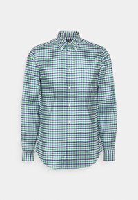 Knappad långärmad skjorta med blå, grön och vit rutmönster och knapp-ner krage på en enfärgad bakgrund.