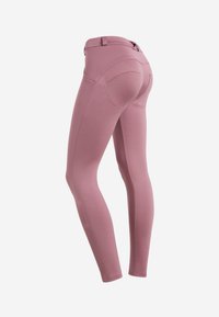 Leggings rosa con un design aderente, texture liscia e dettagli delle cuciture sottili. Presentano una vita alta e tasche posteriori.