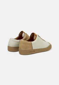 Sneakers in pelle con blocchi di colore bianco e beige, punta rotonda, lacci e suola in gomma testurizzata. Nome del marchio "camper" impresso sul tallone.