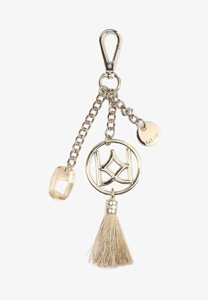 Kovový přívěsek na klíče s karabinou, s kulatým přívěskem, čirým fasetovaným kamenem a béžovým třásním. Akcenty v stříbrném tónu.