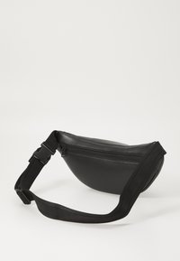 Schwarze Kunstleder-Gürteltasche mit kurviger Form, Reißverschlusstasche und verstellbarem Nylonriemen. Glatte Textur im minimalistischen Stil.