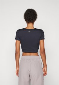 Top sportivo accorciato blu navy con maniche corte e scollatura rotonda; presenta un logo bianco sul retro. Materiale morbido e aderente.