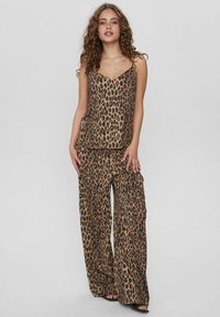 Set format dintr-o camasă cu imprimeu de leopard și pantaloni largi, realizat dintr-un material neted, având o croială lejeră și bretele subțiri.