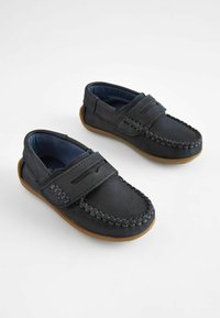 Mocassini in pelle blu scuro, con design mocassino, dotati di cuciture decorative e una fascia in velcro. Suola in gomma marrone.