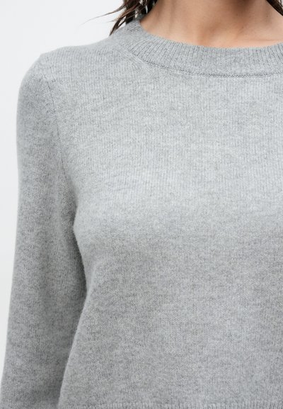 Ανοιχτό γκρι πλεκτό πουλόβερ με στρογγυλή λαιμόκοψη, απαλή υφή και ριμπ λεπτομέρειες στο γιακά και στις μανσέτες.