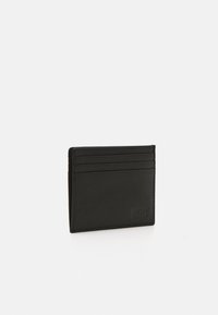 Tarjetero de cuero negro con cuatro ranuras, una superficie texturizada y un logo en relieve en un lado. Diseño rectangular plegado.