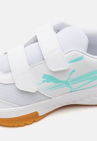 Hvit sportsko med mesh-overdel, to borrelåser og turkise detaljer. Har såle av gummi med strukturert grep og PUMA-logo.