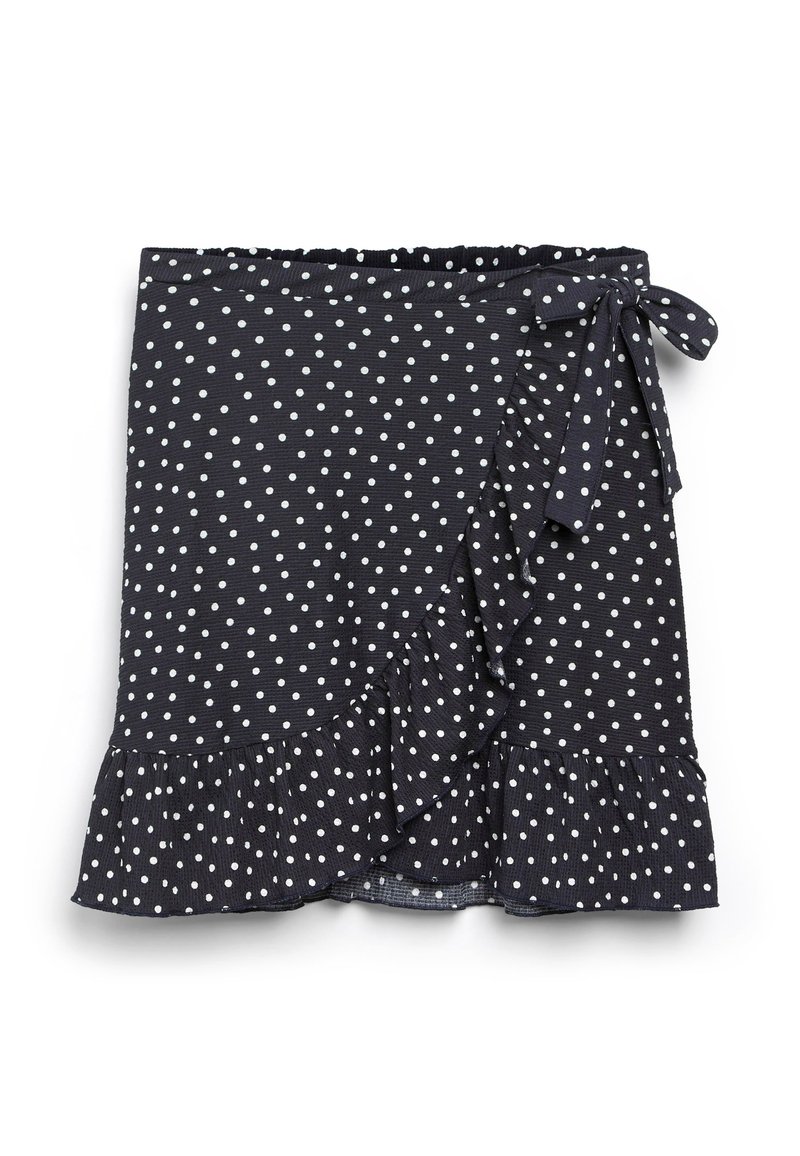 Jupe portefeuille bleu marine à pois blancs, avec ourlet à volants et détail noué à la taille. Fabriquée en matière texturée.