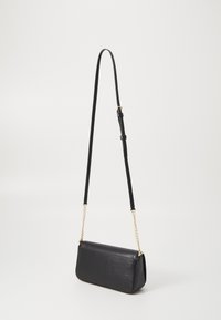 Svart lær crossbody-veske med teksturert finish, funksjoner en lang justerbar stropp og detaljer i gulltonekjede. Rektangulær form.